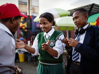 Michelle Selemela (d) et Jennifer Ngobeni, animatrices d'une radio communautaire, interviewe un homme dans le township d'Alexandra, le 14 mars 2019 à Johannesburg, en Afrique du Sud - GULSHAN KHAN [AFP]