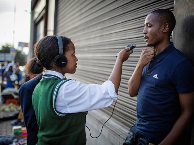 Jennifer Ngobeni, 16 ans, animatrice d'une radio communautaire, interviewe un homme dans le township d'Alexandra, le 14 mars 2019 à Johannesburg, en Afrique du Sud - GULSHAN KHAN [AFP]