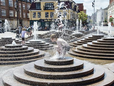 Des habitants se rafraichissent dans les fontaines de la Toldbod Plads à Aalborg, au Danemark, le 24 juillet 2019 - Henning Bagger [Ritzau Scanpix/AFP]