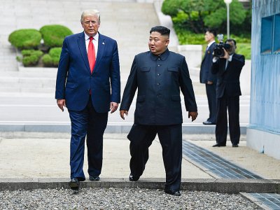 Le président américain Donald Trump et le leader nord-coréen Kim Jong Un traversent la ligne de démarcation entre les deux Corées, le 30 juin 2019 dans la zone démilitarisée de Panmunjon. - Brendan Smialowski [AFP/Archives]