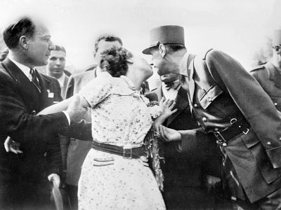 Une Parisienne manifeste sa joie en embrassant le général de Gaulle qui défile sur les Champs-Elysées après la libération - - [AFP]