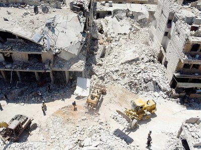 Les secouristes s'activent au pied d'un immeuble détruit par un bombardement, à Maaret al-Noomane, dans le nord-ouest de la Syrie, le 22 juillet 2019 - Omar HAJ KADOUR [AFP]