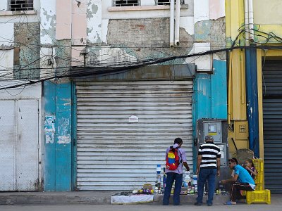 Des vendeurs de rue installés devant des boutiques fermées à Maracaibo - Federico PARRA [AFP]