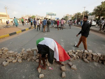 Un manifestant soudanais utilise des pierres pour construire une barricade lors d'un rassemblement dans la capitale Khartoum pour dénoncer le meurtre de 5 lycéens lors d'une manifestation à Al-Obeid (centre) le 29 juillet 2019 - ASHRAF SHAZLY [AFP]