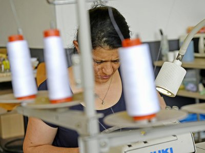 Une femme travaille dans l'atelier de l'association Plateau Fertile, le 25 juillet 2019 à Roubaix - FRANCOIS LO PRESTI [AFP]