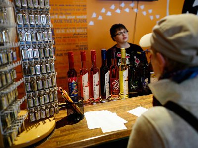 Une touriste regarde des bouteilles de liqueur dans la boutique d'Auk Island Winery à Twillingate, à Terre-Neuve, au Canada, le 2 juillet 2019 - Johannes EISELE [AFP]