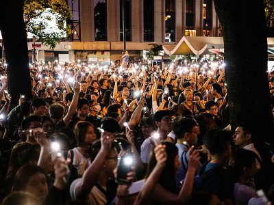 Des protestataires brandissent la lumière de leur téléphone portable lors d'une manifestation de fonctionnaires dans le centre-ville de Hong Kong, le 2 août 2019 - Laurel Chor [AFP]