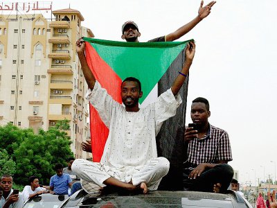 Des Soudanais célèbrent un accord entre militaires et contestation, à Khartoum, le 3 août 2019 - Ebrahim HAMID [AFP]