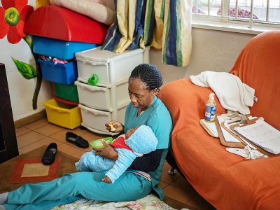 Une nurse nourrit un bébé abandonné à l'orphelinat Door of Hope, le 27 juin 2019 à Johannesburg, en Afrique du Sud - Michele Spatari [AFP]