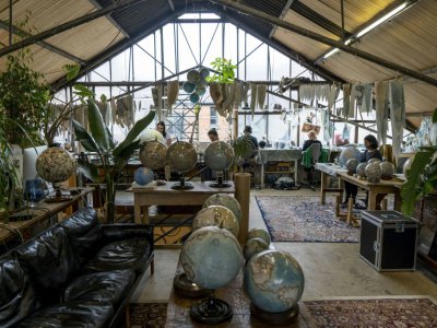 Les artisans travaillent sur la fabrication de globes terrestres dans l'atelier de Bellerby and Co, le 19 juillet 2019 à Londres - Niklas HALLE'N [AFP]