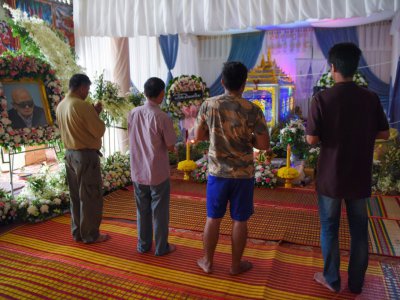 Des hommes se recueillent devant le cercueil de Nuon Chea, le "Frère numéro deux" des Khmers rouges, le 9 août 2019 dans un temple à Pailin, au Cambodge - TANG CHHIN Sothy [AFP]