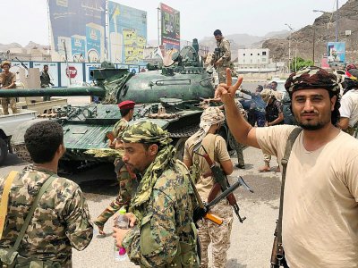 Des séparatistes du sud du Yémen posent devant un char confisqué sur une base militaire gouvernementale à Aden, le 10 août 2019 - Nabil HASAN [AFP]