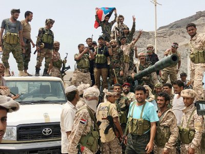 Des séparatistes du sud du Yémen posent devant un char confisqué sur une base militaire gouvernementale à Aden, le 10 août 2019 - Nabil HASAN [AFP]