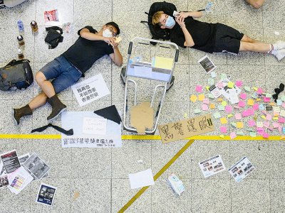 Des manifestants prodémocratie se reposent lors d'une manifestation à l'aéroport international de Hong Kong le 12 août 2019 - Philip FONG [AFP]