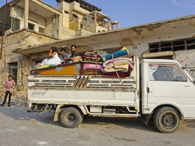 Un famille de déplacés syriens, qui ont fuit leur ville natale de Khan Cheikhoun, arrive dans la ville de Binnish, dans la province d'Idleb, le 14 août 2019 en Syrie - Muhammad HAJ KADOUR [AFP]