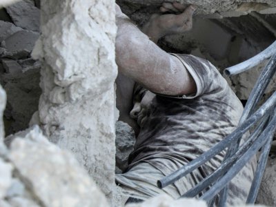 Le corps d'un Syrien dans les décombres d'une construction après une frappe aérienne sur Maaret al-Noomane dans le sud de la province d'Idleb, le 14 août 2019 - Abdullah Hammam [AFP]