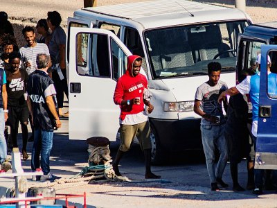 Vingt-sept migrants mineurs non-accompagnés, secourus par le navire de l'ONG espagnole Proactiva Open Arms, sont conduits vers des véhicules de la police italienne avant de quitter le port de Lampedusa où ils ont débarqué le 17 août 2019 - Alessandro SERRANO [AFP]