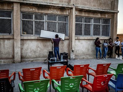 Installation d'un écran de cinéma de plein air pour diffuser un film dans une école de Sanjak Saadoun, en Syrie, le 28 juillet 2019 - DELIL SOULEIMAN [AFP]