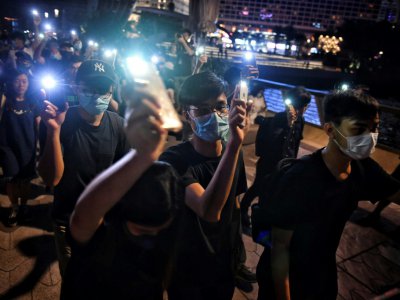 Des milliers de manifestants pro-démocratie unis dans une chaîne humaine brandissent leurs téléphones portables allumés à Hong Kong, le 23 août 2019 - Lillian SUWANRUMPHA [AFP]