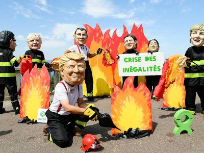 Des activistes de l'organisation Oxfam portant des masques représentant les dirigeants du G7 manifestent en marge du sommet du G7 à Biarritz, le 23 août 2019. - Bertrand GUAY [AFP]
