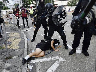 Des policiers anti-émeutes arrêtent une manifestante dans la baie de Kowloon à Hong Kong le 24 août 2019 - Anthony WALLACE [AFP]