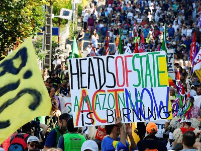 Des milliers d'opposants au G7 ont déflié samedi d'Hendaye à Irun, ici avec une pancarte appelant les chefs d'Etat réunis à Biarritz à agir pour stopper les feux en Amazonie - GEORGES GOBET [AFP]