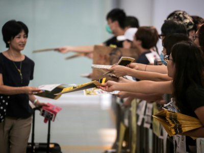Des manifestants pro-démocratie distribuent des tracts aux passagers débarquant à l'aéroport de Hong Kong, le 10 août 2019 - VIVEK PRAKASH [AFP/Archives]