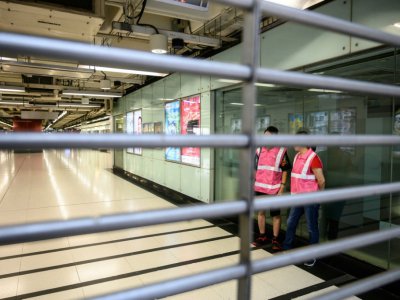 Des employés du métro dans une station fermée avant une manifestation dans le quartier de Tsuen Wan, le 25 août 2019 à Hong Kong - Philip FONG [AFP]