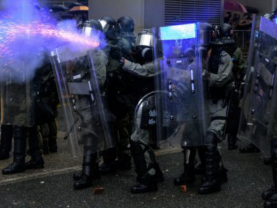 Des policiers tirent des gaz lacrymogènes contre des manifestants à Hong Kong le 25 août 2019 - Philip FONG [AFP]