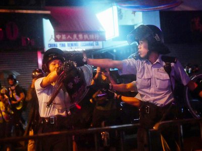 Des policiers pointent leurs armes sur des manifestants, le 25 août 2019 à Hong Kong - Lillian SUWANRUMPHA [AFP]