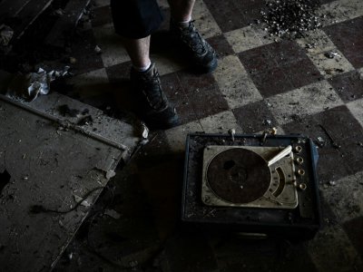 Un adepte de l'urbex, l'exploration urbaine, découvre un vieux tourne-disques dans un corps de ferme abandonné, le 22 août 2019 au nord de Paris - Philippe LOPEZ [AFP]
