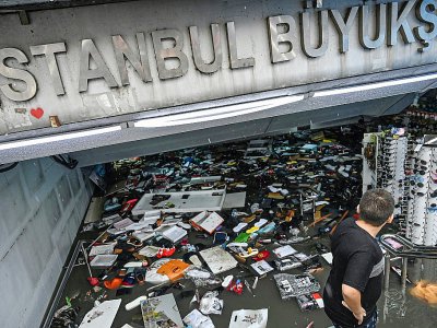 Un commerçant tente de sauver sa marchandise dans un centre commercial du quartier d'Eminonu à Istanbul, le 17 août 2019. - Ozan KOSE [AFP]