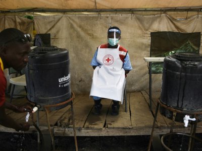 Un membre du personnel sanitaire veille à ce que les gens se lavent les mains pour lutter contre l'épidémie d'Ebola à la frontière entre la RDC et l'Ouganda, le 13 juin 2019. - ISAAC KASAMANI [AFP/Archives]