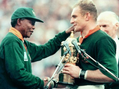 Le capitaine des Springboks François Pienaar reçoit le trophée Webb Ellis des mains du président Nelson Mandela, le 4 juin 1995 à Johannesburg - Jean-Pierre MULLER [AFP/Archives]