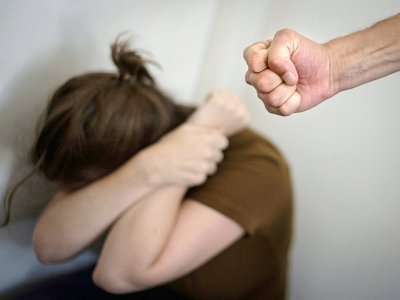 Une femme se cache le visage devant le poing d'un homme, reproduisant une supposée scène de violence domestique - LOIC VENANCE [AFP/Archives]