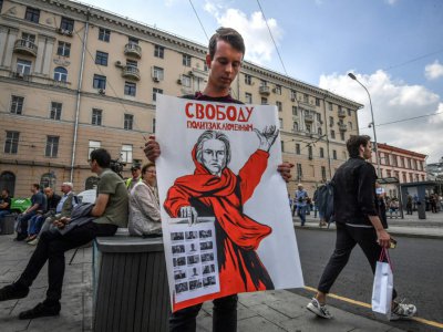 Un homme porte une pancarte "Libérez les prisonniers politiques" à Moscou le 31 août 2019 - Yuri KADOBNOV [AFP]