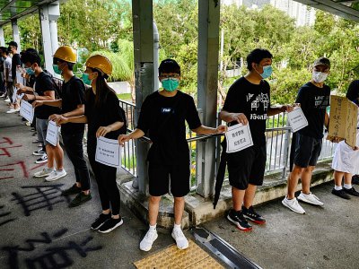 Des étudiants participent à une chaîne humaine pour demander notamment une enquête sur le comportement de la police et une amnistie pour les protestataires arrêtés, le 5 septembre 2019 à Hong Kong - Philip FONG [AFP]