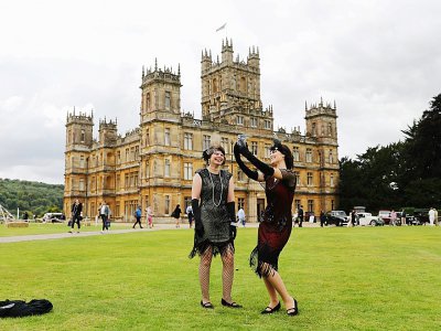 Des fans en tenue d'époque devant le chateau de Highclere, où le tournage de la série et du film a eu lieu, à l'ouest de Londres le 7 septembre 2019 - Isabel INFANTES [AFP]