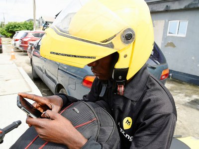 Un moto-taxi de MaxOkada consulte son smartphone, le 4 septembre 2019 à Lagos, au Nigeria - PIUS UTOMI EKPEI [AFP]