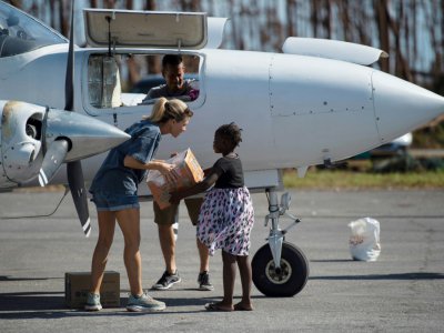 Une volontaire américaine débarque de l'aide humanitaire d'urgence sur l'aéroport de Treasure Cay, sur l'île d'Abaco aux Bahamas, le 11 septembre 2019 - Andrew CABALLERO-REYNOLDS [AFP]