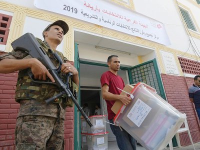 Un membre de l'instance chargée des élections en Tunisie apporte des urnes dans un bureau de vote à la veille du scrutin présidentiel, le 14 septembre 2019 à Tunis - Fethi Belaid [AFP]