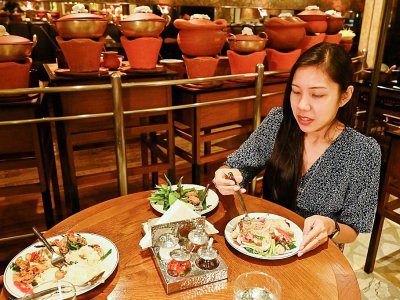 Une enseignante, Diane Piroon, goûte un plat végétarien dans un restaurant de Bangkok, le 9 septembre 2019 - Romeo GACAD [AFP]