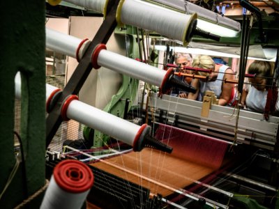 Des artisans s'activent sur une machine à soie de la manufacture Prelle, le 16 septembre 2019 à Lyon - JEAN-PHILIPPE KSIAZEK [AFP]