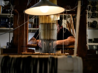 Un artisan travaille sur un métier à soie, à la manufacture Prelle, le 16 septembre 2019 à Lyon - JEAN-PHILIPPE KSIAZEK [AFP]