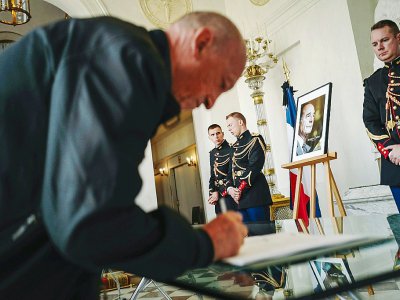 Un homme signe un registre de condoléances pour le président Jacques Chirac au Palais de l'Elysée, le 28 septembre 2019. - LUCAS BARIOULET [AFP]