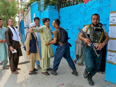 Un membre des forces de sécurité fouille les électeurs à l'entrée d'un bureau de vote pour l'élection présidentielle à Jalalabad, en Afghanistan, le 28 septembre 2019. Les talibans avaient menacé d'attaques sur les bureaux de vote, et plus de 400 att - Noorullah SHIRZADA [AFP]