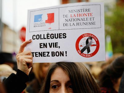 Une femme tient une pancarte dans la manifestation organisée à Bobigny le 3 octobre 2019, dix jours après le suicide de Christine Renon, directice d'école à Pantin (Seine-Saint-Denis) - Thomas SAMSON [AFP]