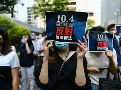 Un manifestant pro-démocratie porte un panneau exprimant son opposition à la loi interdisant de porter des masques pendant les manifestations, à Hong Kong le 4 octobre 2019 - Mohd RASFAN [AFP]