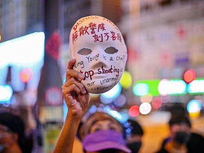 Un manifestant tient un masque sur lequel sont inscrits des slogans, le 5 octobre 2019 à Hong Kong - Philip FONG [AFP]