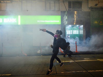 Un manifestant hongkongais renvoie une cartouche de gaz lacrymogène tirée par la police lors d'échauffourées le 7 octobre 2019 dans le district de Mongkok - Mohd RASFAN [AFP]